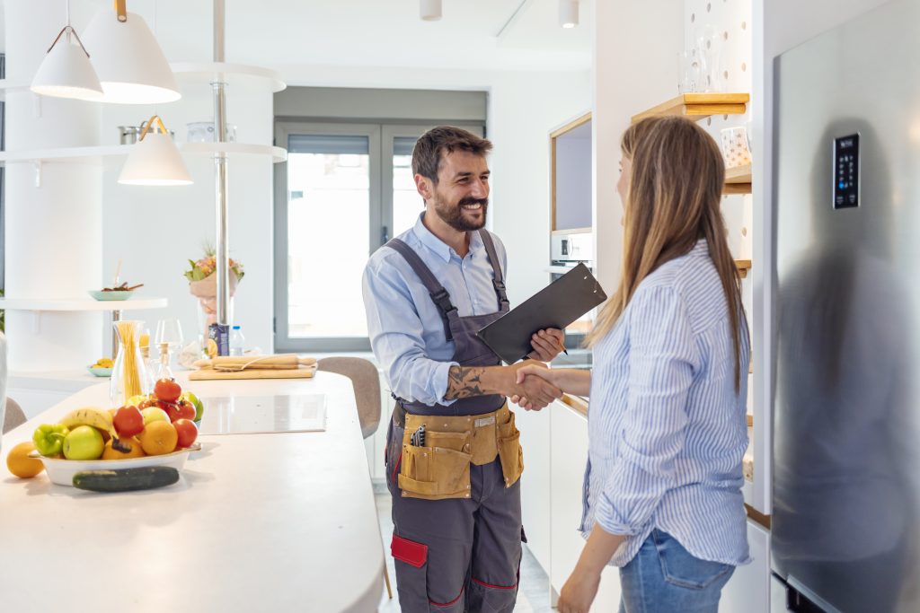 Young Woman Shaking Hands To Male Plumber