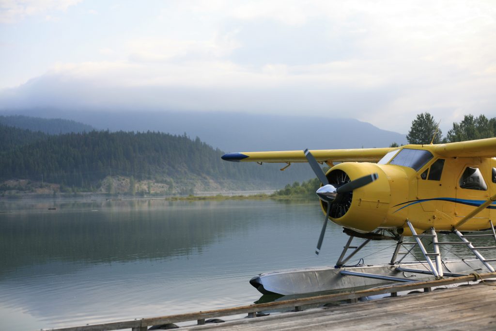 Fload plane sitting close to a dock by a foggy, calm lake in Ontario