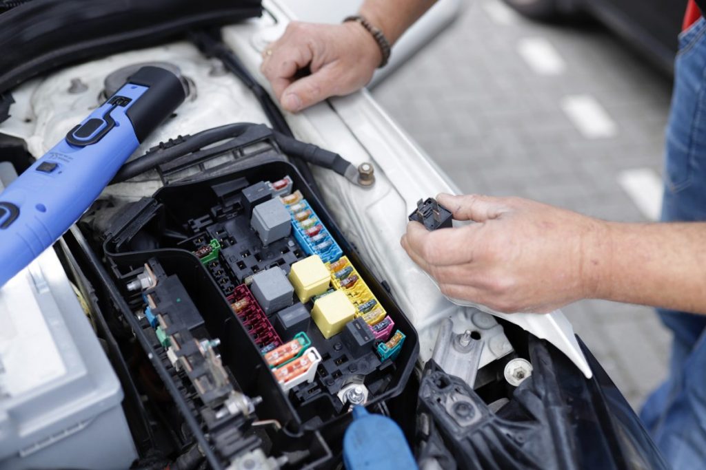 Car mechanic working on a electronic car