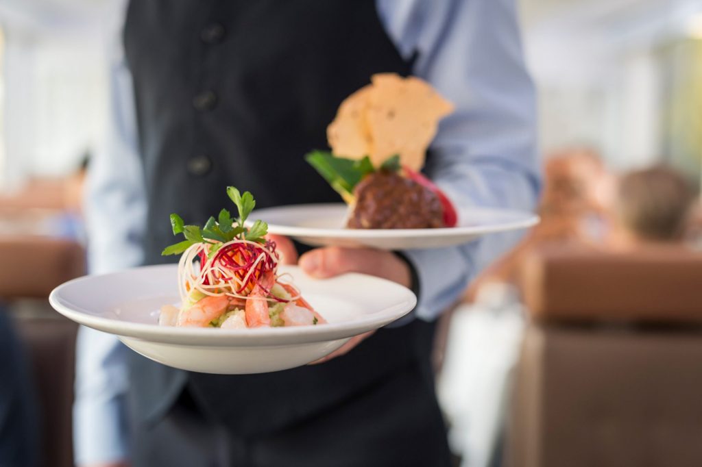 a Rocky Mountaineer server carries plants