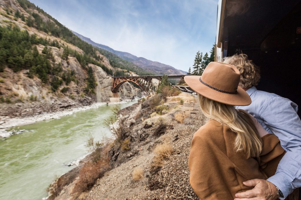 A couple over looks the water on the rocky mountaineer