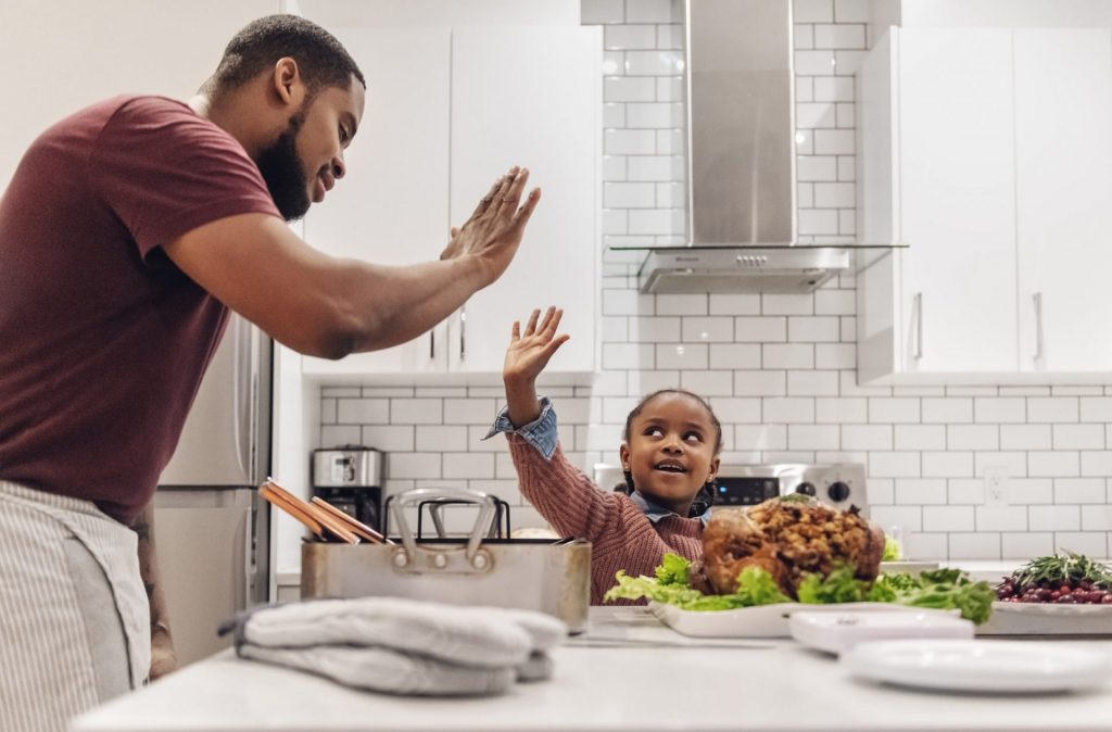 a family cooks thanksgiving turkey dinner together