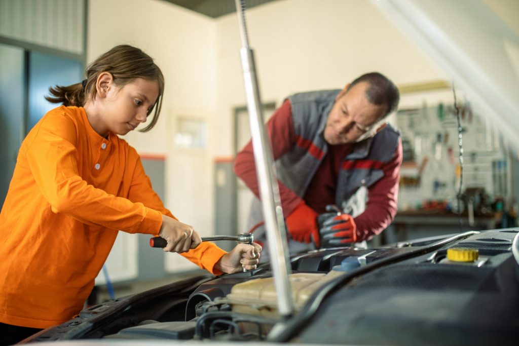 man and his son perfomring car maintenace