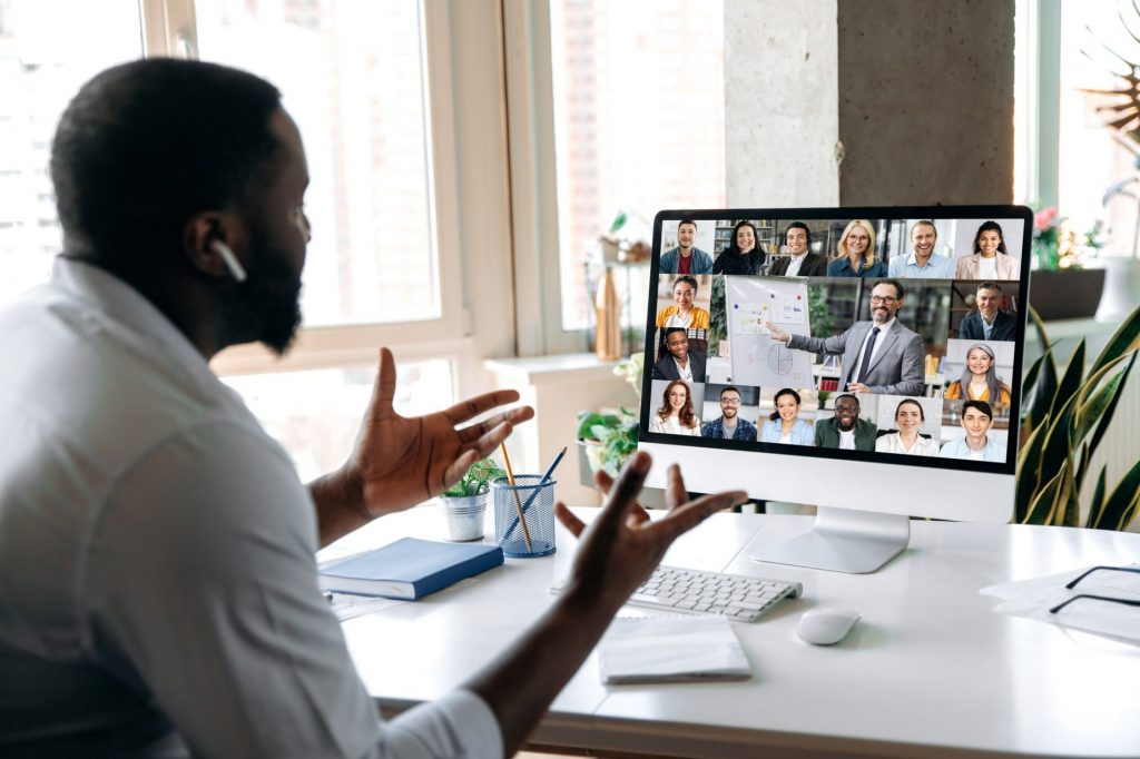 A man is presenting on zoom in his work from home office