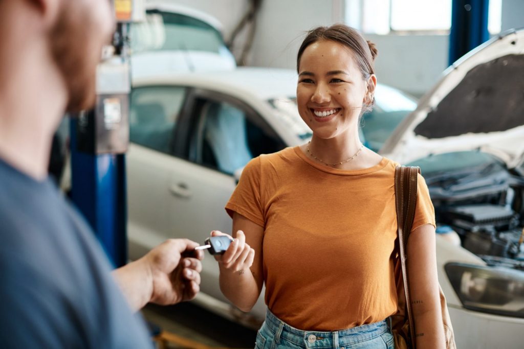 Woman ahnding car keys over the a mechanic for regular car maintenance