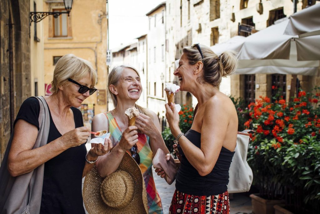 Friends eat local Italian gelato while travelling