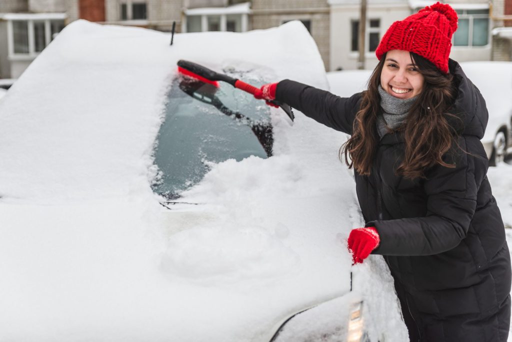 cleaning snow off of a car