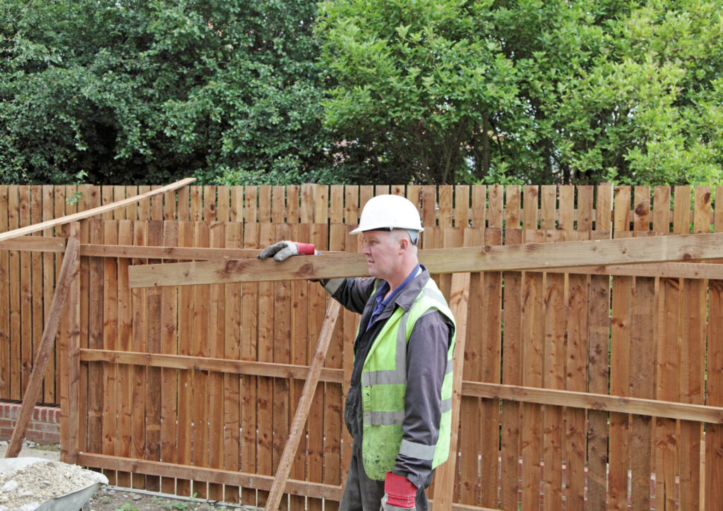 construction worker carrying timber.