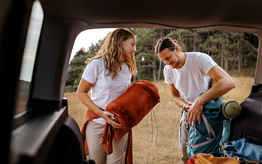 Young couple preparing gear for hike