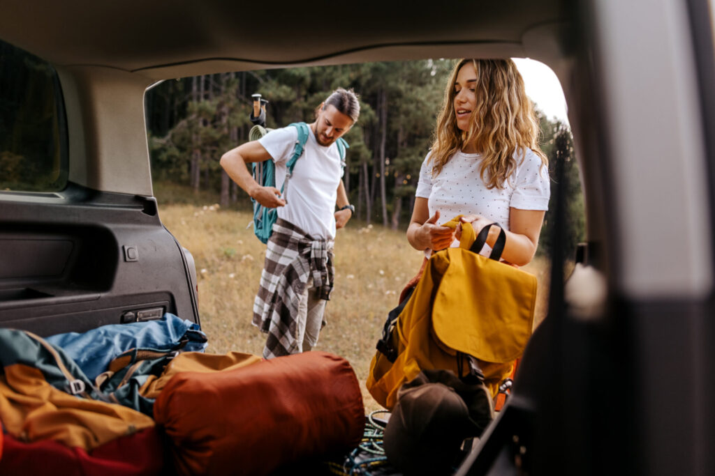 Young couple preparing gear for hike