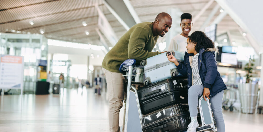 Tourist family with luggage trolley at airport