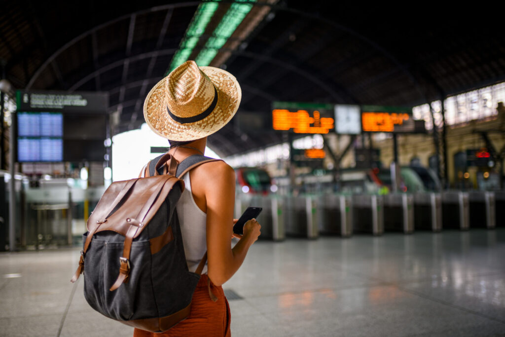 Female traveler at the train station waiting for her train.