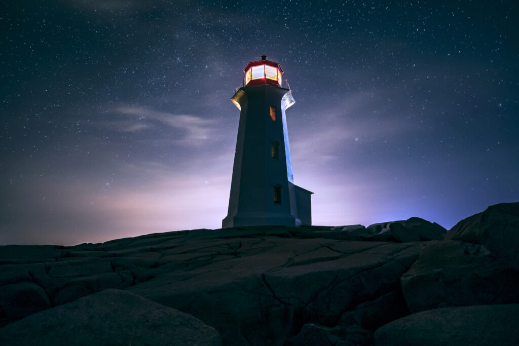 Peggy's Cove Lighthouse against a starry backdrop; Nova Scotia, Canada.